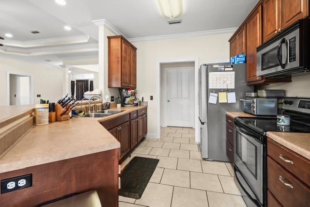 115 Brittany Dr, Dothan, AL 36301 - kitchen with stainless steel appliances, ornamental molding, a peninsula, light tile patterned floors, and light countertops