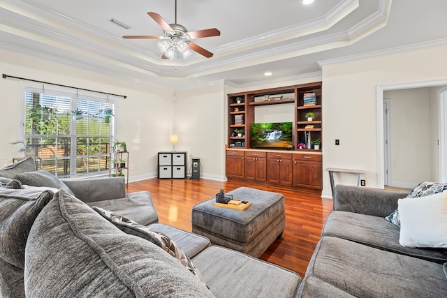 115 Brittany Dr, Dothan, AL 36301 - living room featuring a tray ceiling, a ceiling fan, wood finished floors, and ornamental molding