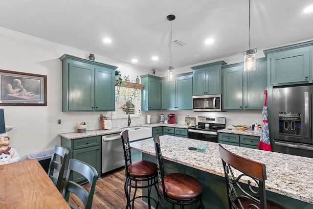 1908 Baxter Rd, Ashford, AL 36312 - kitchen featuring stainless steel appliances, crown molding, a kitchen bar, hanging light fixtures, and light stone counters