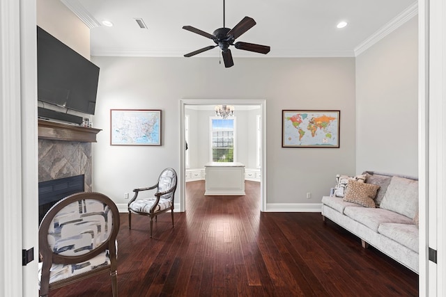 living area with baseboards, dark wood-type flooring, a fireplace, and crown molding