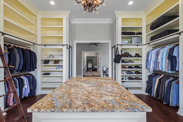 walk in closet featuring dark wood finished floors and ceiling fan with notable chandelier