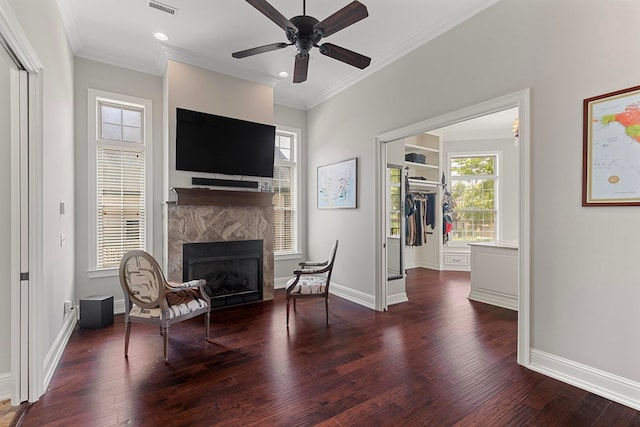 sitting room with baseboards, crown molding, a fireplace, and hardwood / wood-style flooring