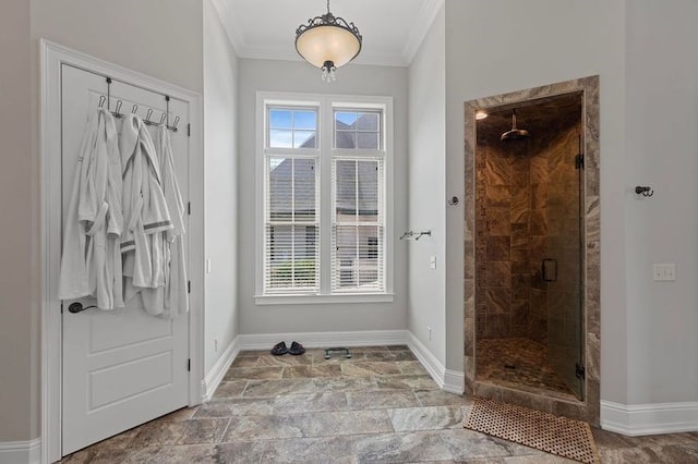 bathroom featuring a shower stall, crown molding, and baseboards