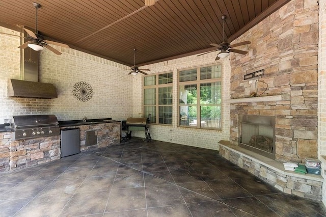 view of patio / terrace featuring grilling area, exterior kitchen, an outdoor stone fireplace, and ceiling fan