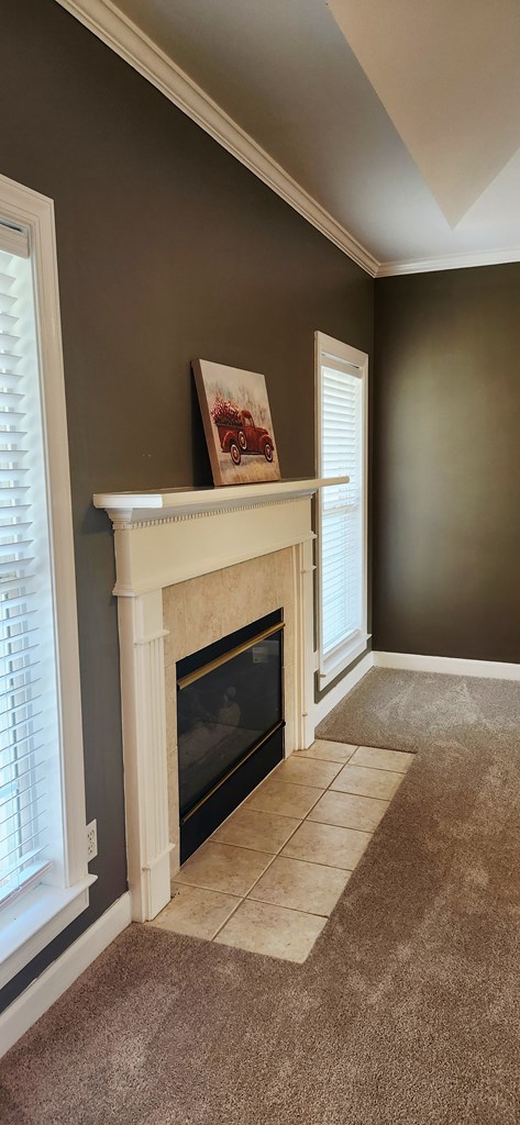 301 Roslyn Glen Way, Dothan, AL 36305 - unfurnished living room with carpet flooring, a tile fireplace, and ornamental molding