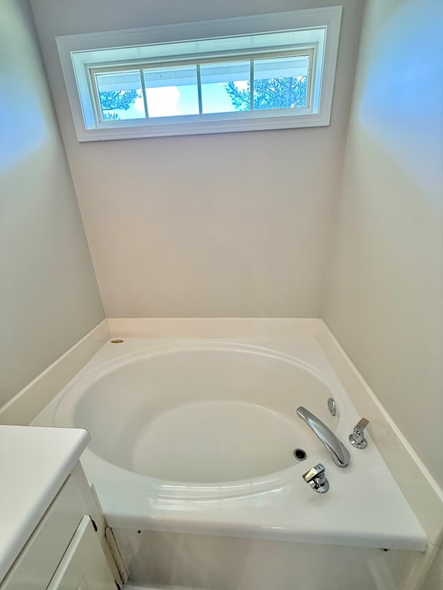 full bathroom with vanity, a bath, and a healthy amount of sunlight