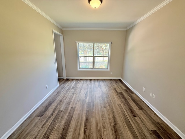 spare room with baseboards, ornamental molding, and dark wood finished floors