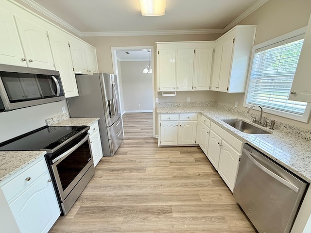 kitchen featuring a sink, appliances with stainless steel finishes, crown molding, white cabinets, and light wood-style floors