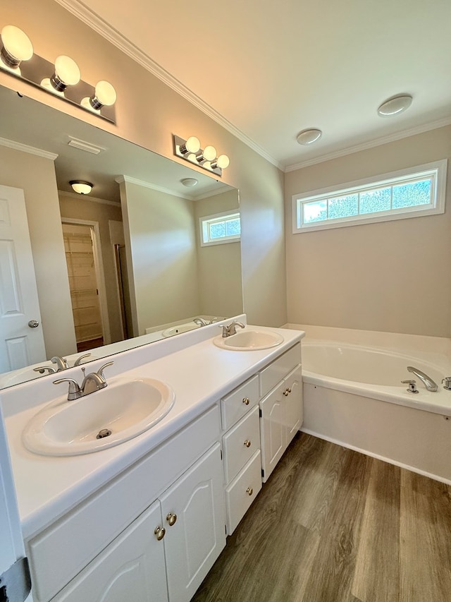 full bath featuring a sink, double vanity, a garden tub, and wood finished floors