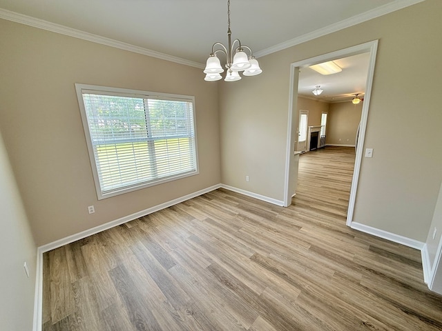 unfurnished room featuring light wood-type flooring, baseboards, and crown molding