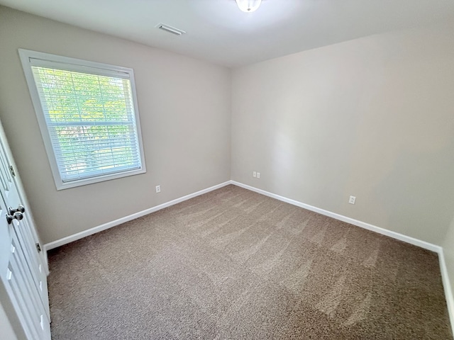 carpeted empty room with baseboards and visible vents