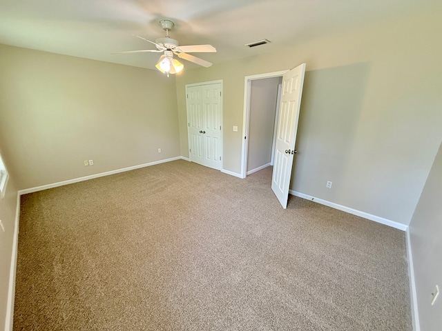 unfurnished bedroom with a closet, visible vents, carpet floors, a ceiling fan, and baseboards
