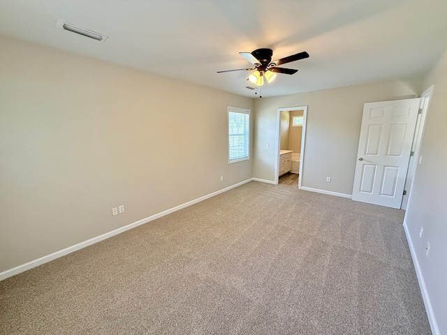 unfurnished bedroom with ensuite bathroom, baseboards, visible vents, ceiling fan, and light carpet