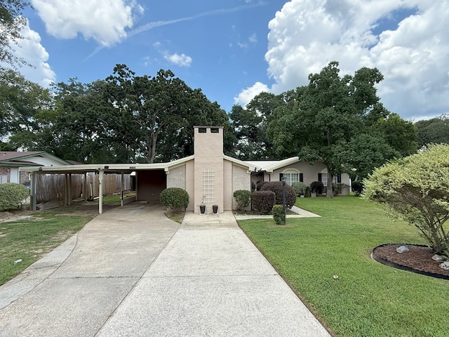 26 Goff St, Daleville, AL 36322 - view of front of house with an attached carport, driveway, a chimney, and stucco siding