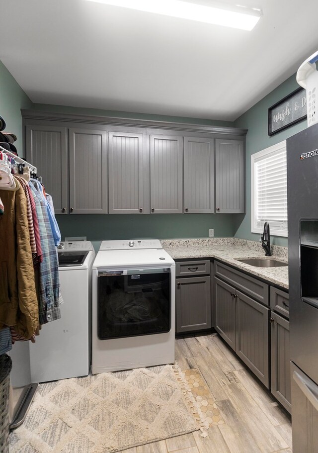 333 County Road 271, Clopton, AL 36317 - laundry room with cabinets, light wood-type flooring, sink, and washing machine and clothes dryer