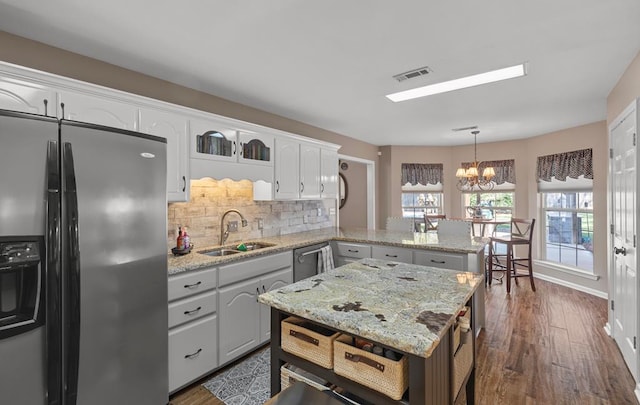 kitchen featuring an inviting chandelier, appliances with stainless steel finishes, decorative light fixtures, dark hardwood / wood-style flooring, and white cabinetry