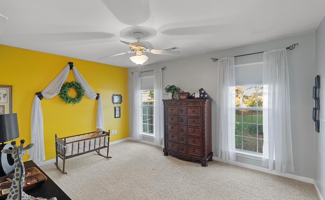 interior space featuring carpet, ceiling fan, and multiple windows