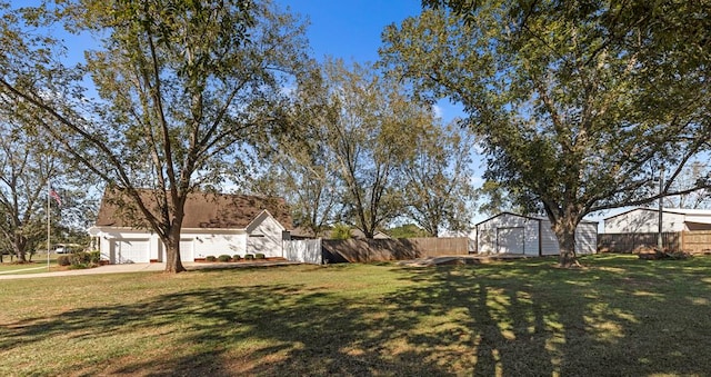 view of yard featuring a garage and an outdoor structure