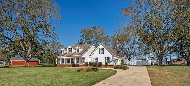 cape cod house featuring a front yard