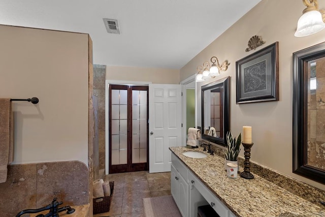 bathroom with french doors, vanity, and tile patterned flooring