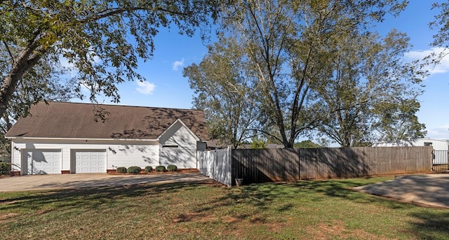 view of side of property with a lawn and a garage