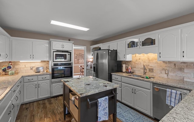 kitchen featuring white cabinetry, sink, dark wood-type flooring, decorative backsplash, and appliances with stainless steel finishes