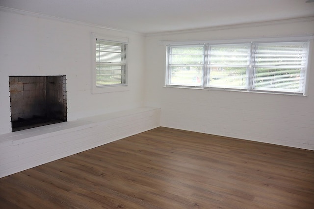 unfurnished living room featuring ornamental molding, wood finished floors, and a fireplace