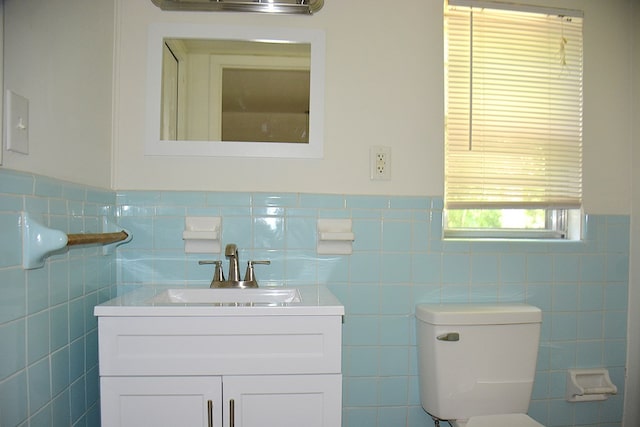 bathroom with vanity, tile walls, toilet, and wainscoting