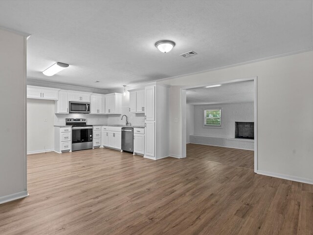 302 Robin Ln, Enterprise, AL 36330 - kitchen featuring stainless steel appliances, open floor plan, white cabinetry, and light wood finished floors