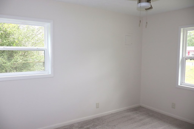 carpeted empty room featuring baseboards and ceiling fan