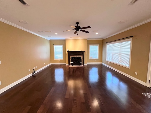 unfurnished living room with ceiling fan, dark hardwood / wood-style flooring, ornamental molding, and a tile fireplace