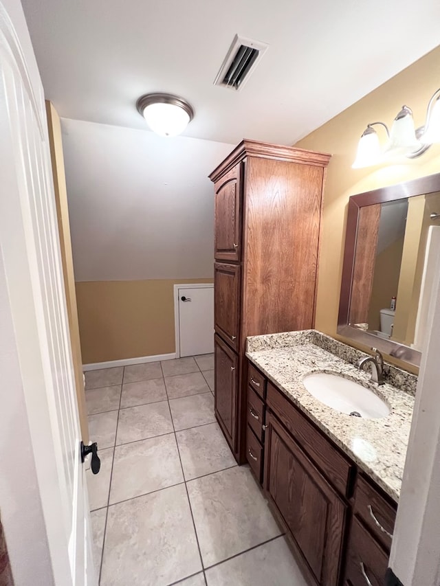 bathroom with tile patterned flooring, vanity, and toilet