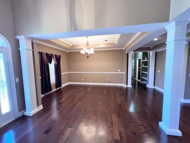 interior space featuring dark wood-type flooring, a raised ceiling, a notable chandelier, decorative columns, and crown molding