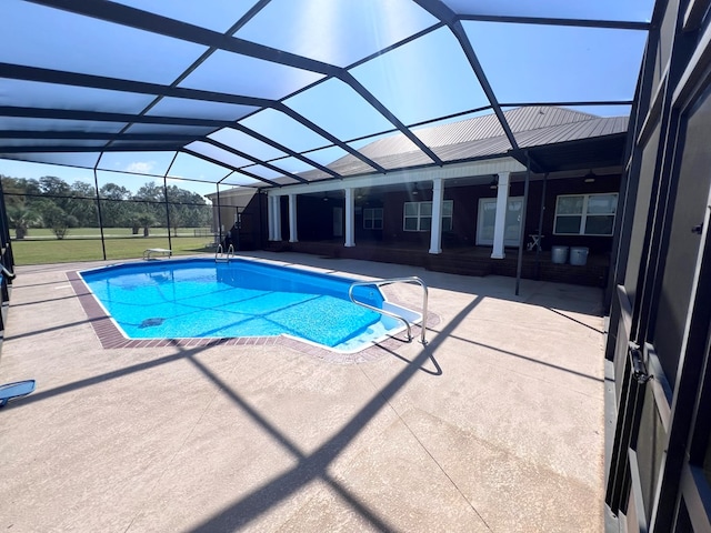 view of swimming pool featuring a patio area and glass enclosure