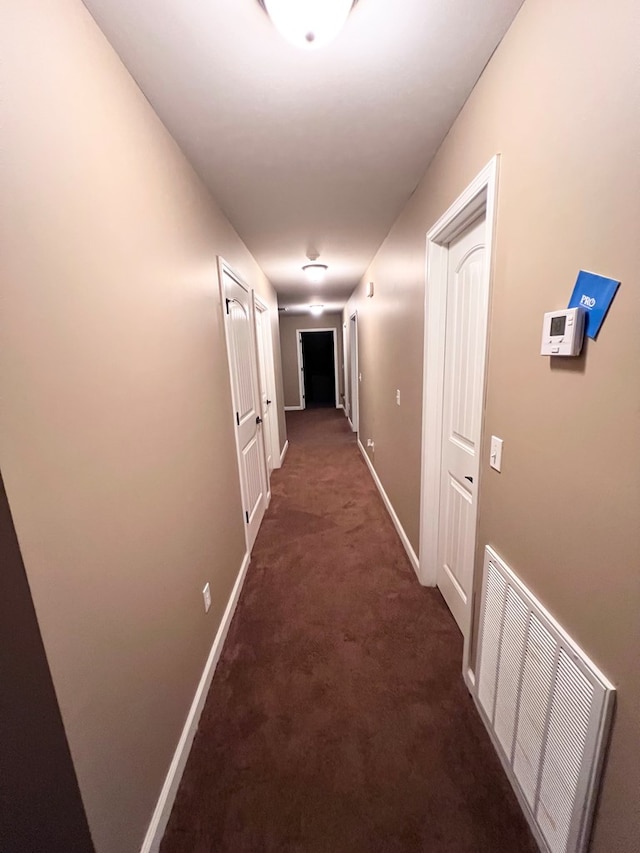 hallway with dark colored carpet