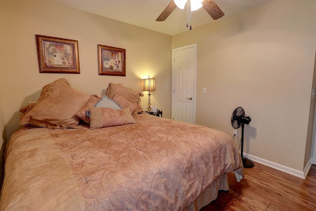 bedroom featuring wood finished floors, baseboards, and ceiling fan