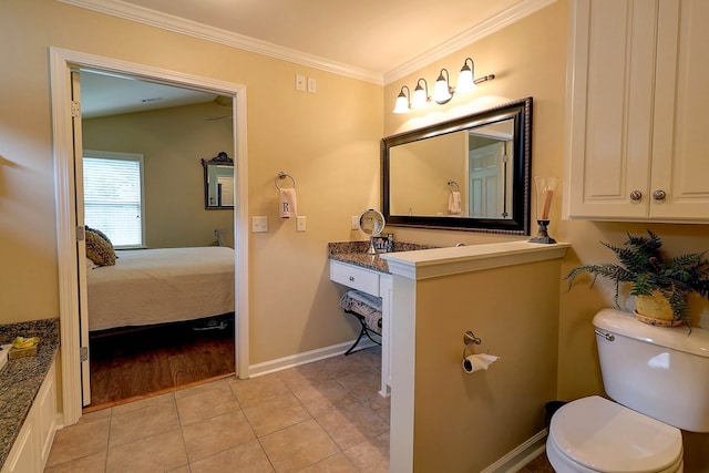 bathroom with ornamental molding, toilet, tile patterned flooring, baseboards, and vanity