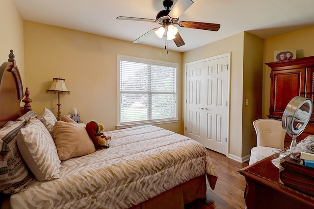 bedroom featuring wood finished floors, a closet, baseboards, and ceiling fan