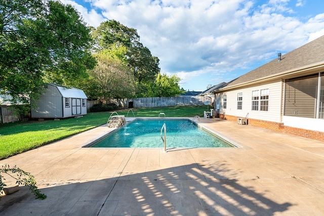 view of swimming pool with pool water feature, a shed, a patio area, and a lawn