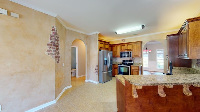 kitchen featuring light stone counters, kitchen peninsula, crown molding, a breakfast bar, and appliances with stainless steel finishes