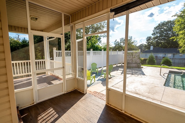 unfurnished sunroom featuring a wealth of natural light and wooden ceiling