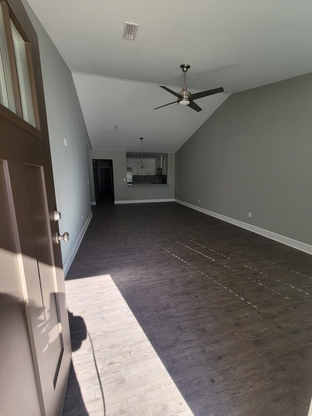 unfurnished living room with ceiling fan, dark hardwood / wood-style floors, and lofted ceiling