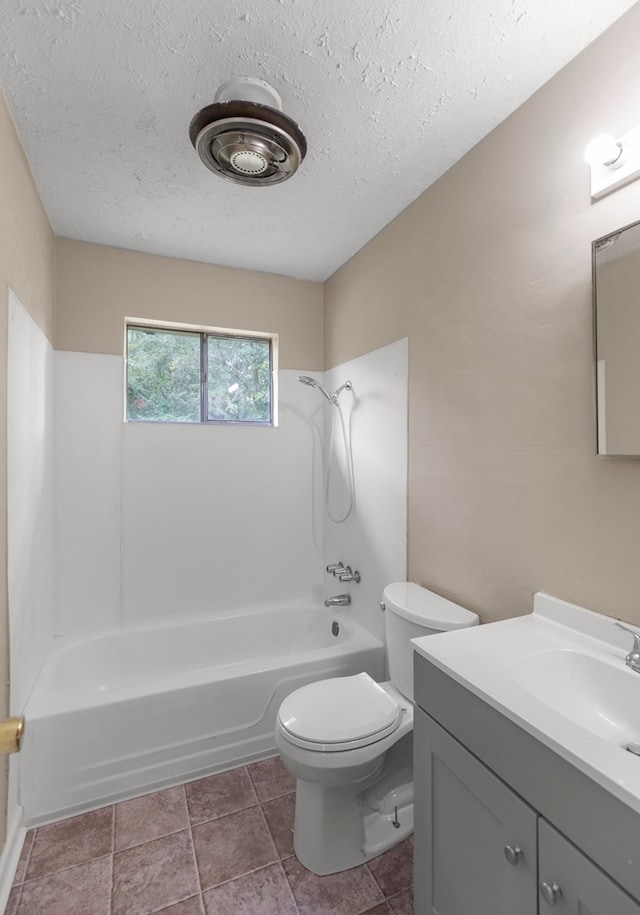 full bathroom featuring tile patterned floors, toilet, a textured ceiling, vanity, and shower / bath combination