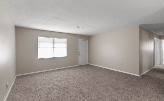 empty room featuring carpet flooring and a textured ceiling