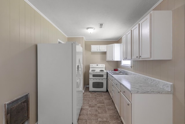 kitchen featuring wood walls, white cabinetry, sink, ornamental molding, and white appliances