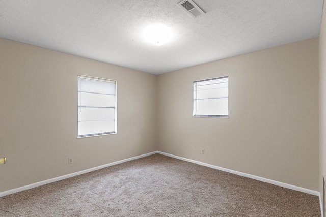 empty room featuring carpet flooring and a textured ceiling