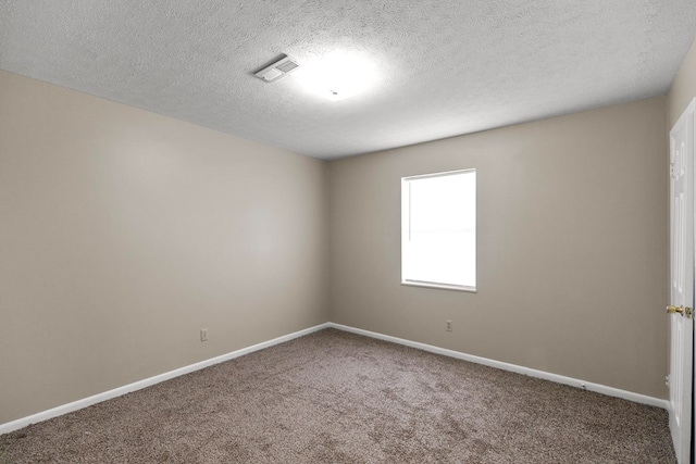 carpeted spare room featuring a textured ceiling