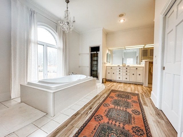 2023 J Saunders Rd, Dothan, AL 36305 - bathroom with a garden tub, vanity, ornamental molding, wood finished floors, and a chandelier
