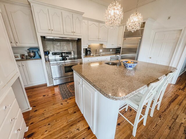 2023 J Saunders Rd, Dothan, AL 36305 - kitchen with stainless steel appliances, under cabinet range hood, a sink, hardwood / wood-style floors, and decorative backsplash