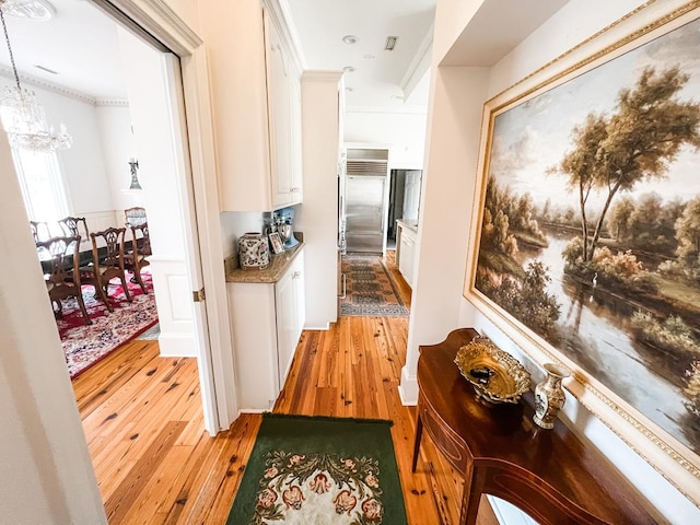 2023 J Saunders Rd, Dothan, AL 36305 - corridor with light wood-style floors, a chandelier, and crown molding